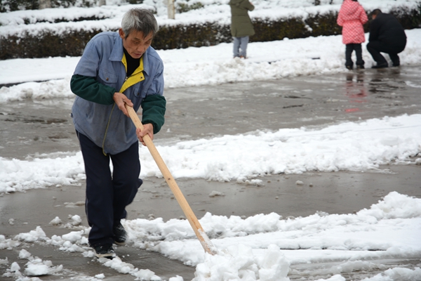 總務(wù)人員清掃校園積雪